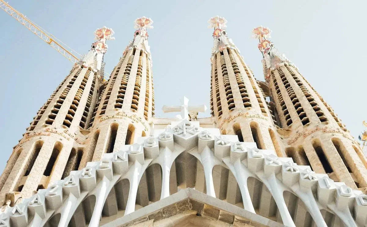 Close-up view of the Sagrada Família's intricately designed towers, showcasing Gaudí's architectural mastery under a clear, bright sky.