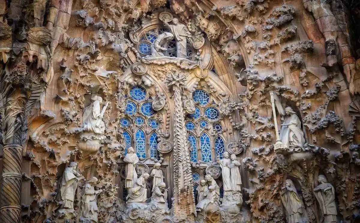 Close-up of the intricate façade of the Sagrada Família, featuring detailed sculptures, stained-glass windows, and unique architectural elements.