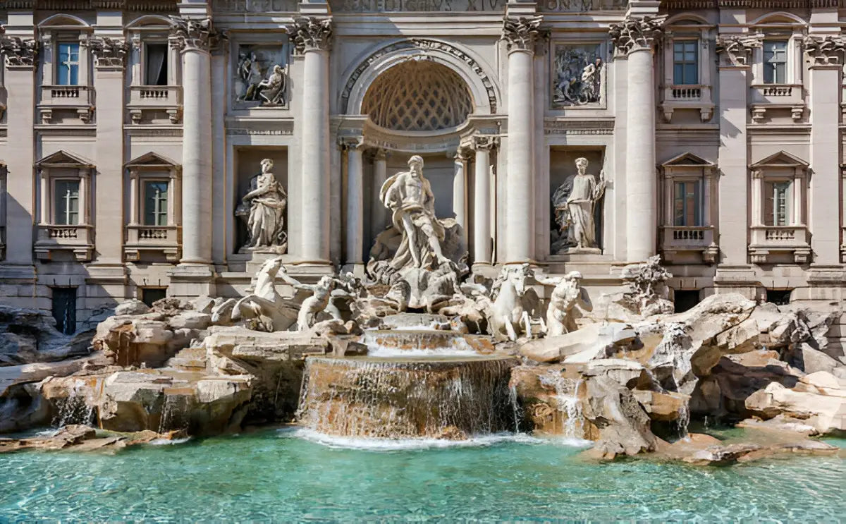 Front view of the Trevi Fountain in Rome, showcasing the intricate sculptures of Oceanus, tritons, and sea horses. The cascading water flows into the large turquoise basin below, surrounded by ornate stonework and the grand baroque facade of Palazzo Poli.
