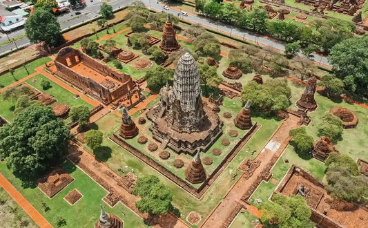 Aerial view of Wat Chaiwatthanaram in Ayutthaya Historical Park, showing the central prang surrounded by smaller stupas and ruins in a symmetrical layout.