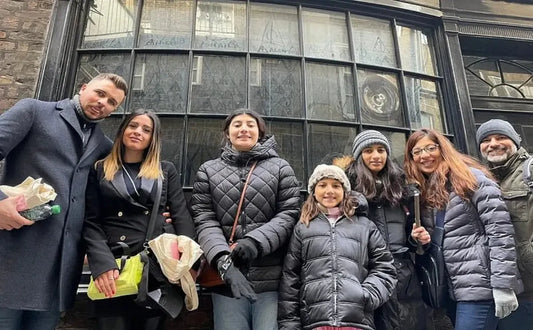 A group of Harry Potter fans pose together during a walking tour in London, standing in front of a location tied to the magical world of the famous series.