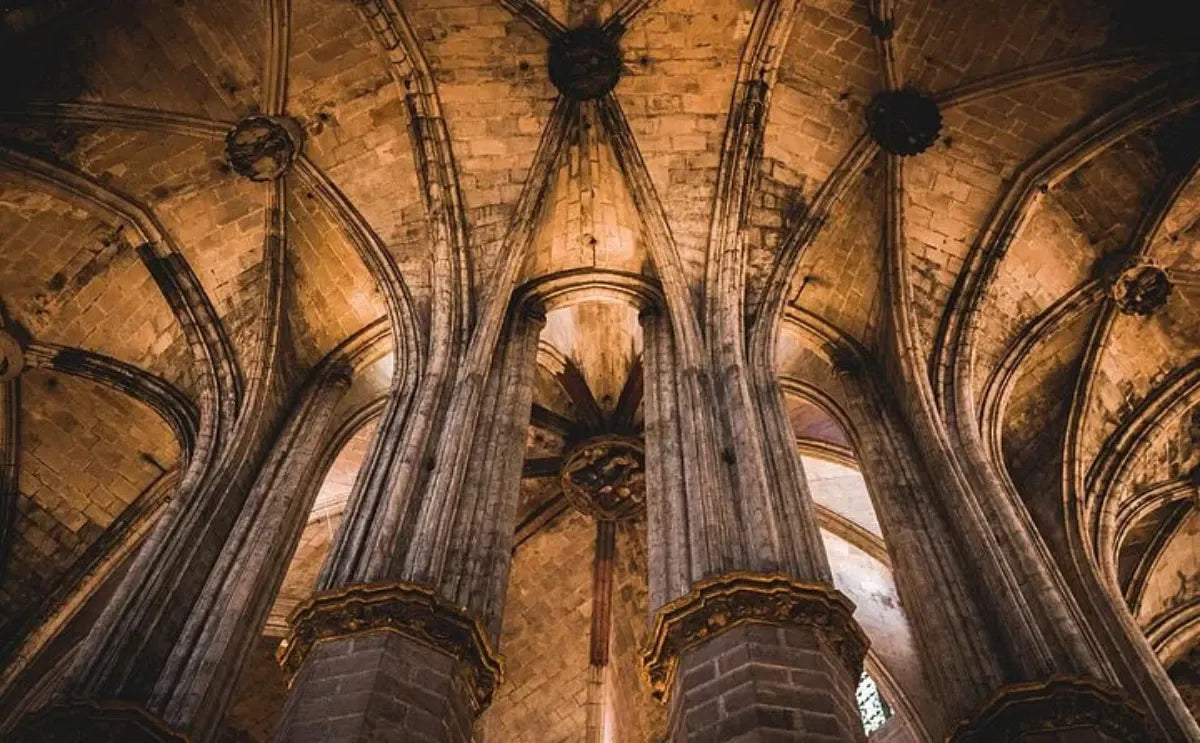 A stunning view of the vaulted ceilings inside the Basilica of Santa Maria del Mar in Barcelona. The intricate Gothic architecture and warm lighting create an atmosphere of awe and reverence.